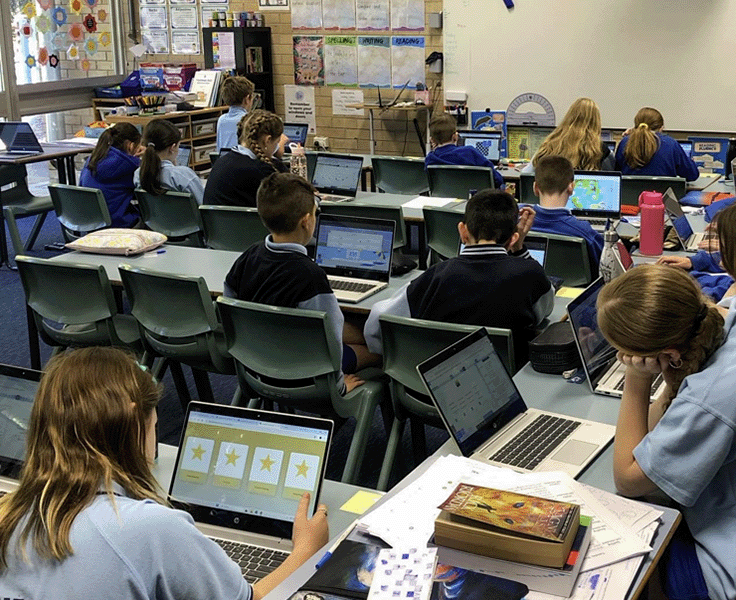 Class with students using laptops
